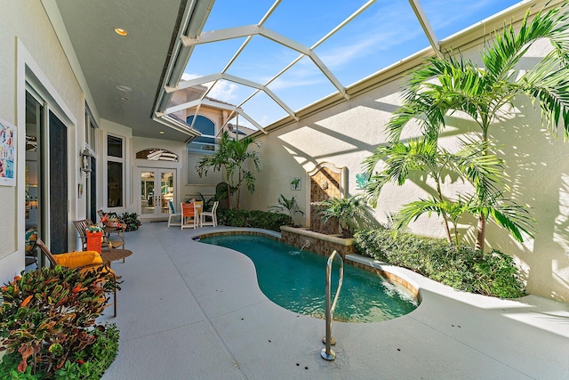 view of swimming pool with french doors, pool water feature, a patio area, and glass enclosure