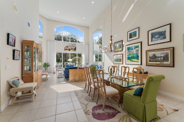 tiled dining space featuring ornamental molding, a high ceiling, and an inviting chandelier