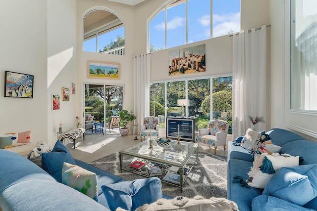 tiled living room featuring a high ceiling and plenty of natural light