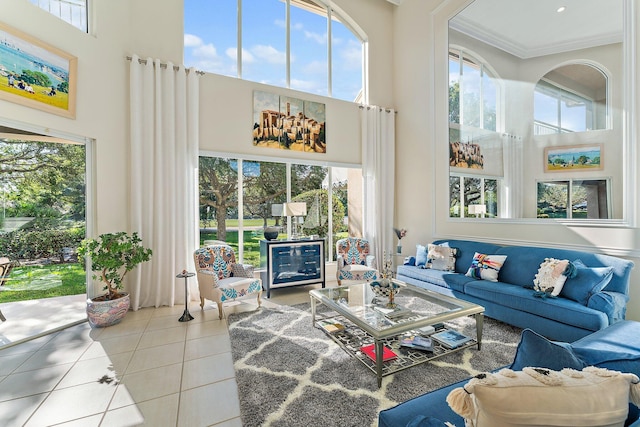 living room with ornamental molding, a high ceiling, and tile patterned floors