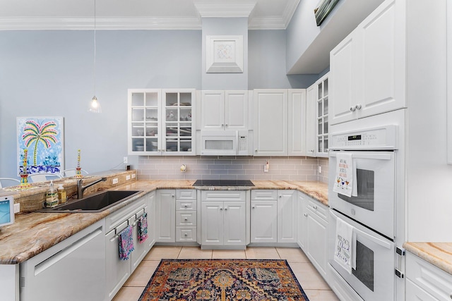 kitchen featuring sink, light stone countertops, light tile patterned floors, white cabinetry, and white appliances