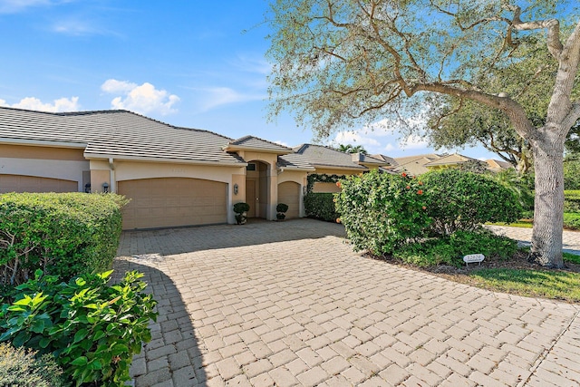 12020 SE Birkdale Run, Jupiter, FL 33469 - mediterranean / spanish house featuring an attached garage, decorative driveway, stucco siding, and a tile roof