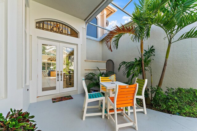 12020 SE Birkdale Run, Jupiter, FL 33469 - property entrance featuring french doors, outdoor dining area, stucco siding, and a patio area