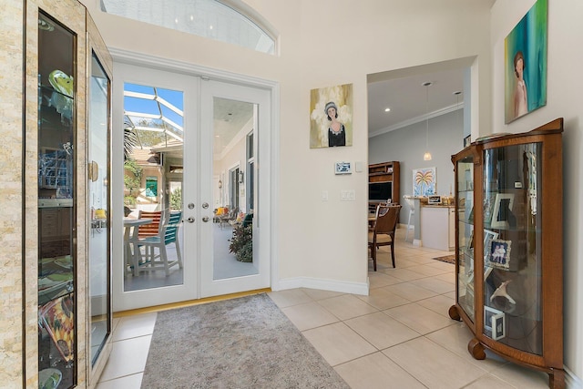 entrance foyer with french doors, ornamental molding, and light tile patterned flooring