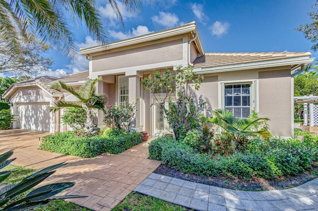 6481 Spartina Cir, Jupiter, FL 33458 - view of front of property featuring stucco siding, an attached garage, and driveway