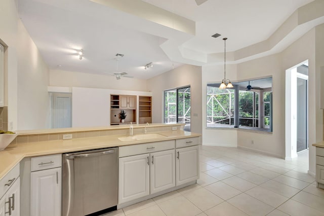 kitchen featuring stainless steel dishwasher, white cabinetry, sink, and light tile patterned floors