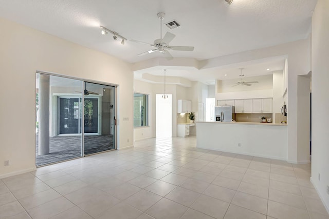 unfurnished living room with a textured ceiling and light tile patterned floors