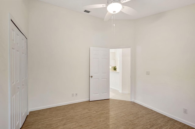 unfurnished bedroom with light hardwood / wood-style flooring, ceiling fan, and a closet