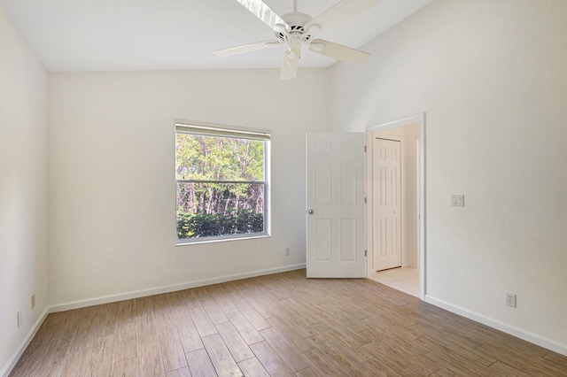 spare room featuring light hardwood / wood-style floors, ceiling fan, and vaulted ceiling