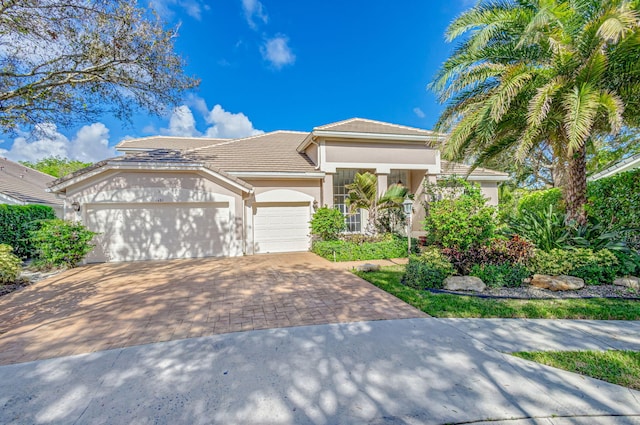 6481 Spartina Cir, Jupiter, FL 33458 - view of front of property with driveway, a garage, stucco siding, and a tiled roof
