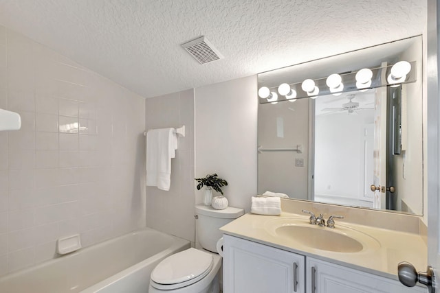 full bathroom with toilet, tiled shower / bath, a textured ceiling, vanity, and ceiling fan