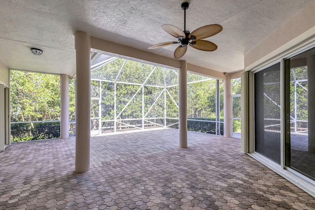 unfurnished sunroom with ceiling fan