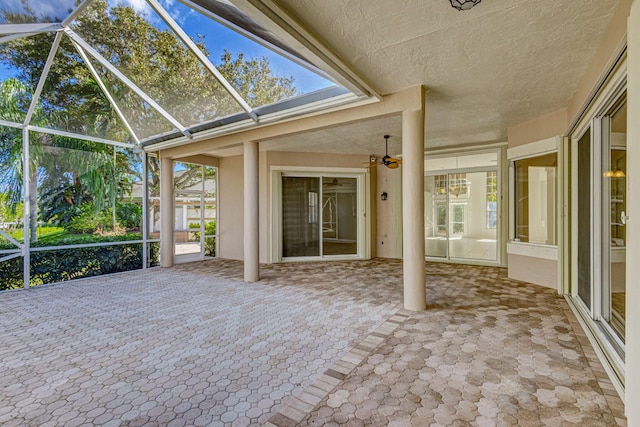 unfurnished sunroom with ceiling fan