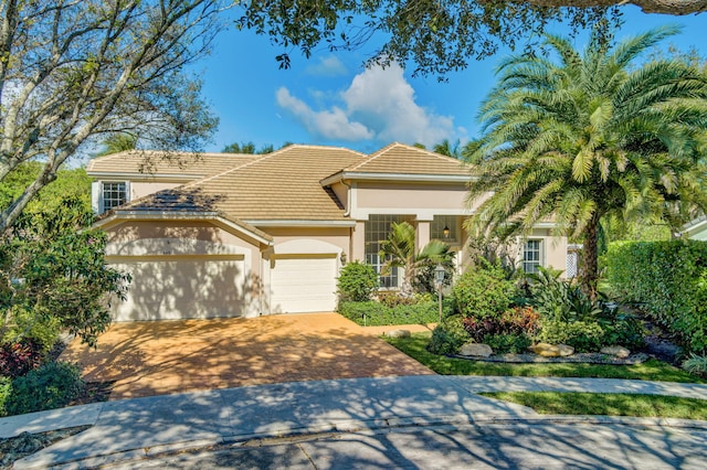 6481 Spartina Cir, Jupiter, FL 33458 - view of front of home featuring driveway, a tiled roof, a garage, and stucco siding