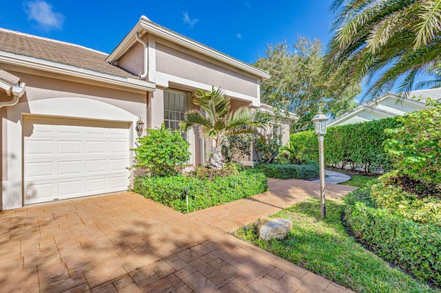 6481 Spartina Cir, Jupiter, FL 33458 - view of front of house featuring stucco siding, an attached garage, and driveway