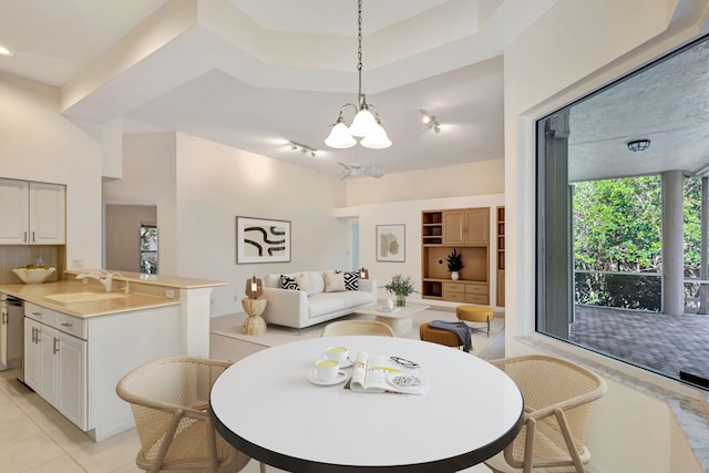 tiled dining space with a notable chandelier, sink, and a high ceiling