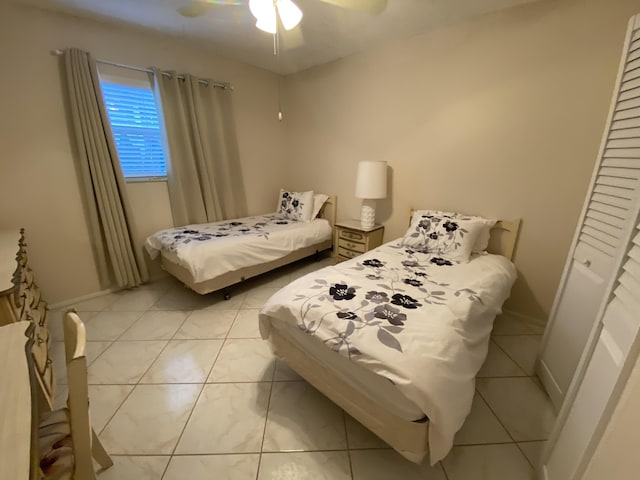 tiled bedroom featuring ceiling fan