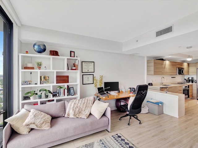 office area featuring light hardwood / wood-style floors and sink