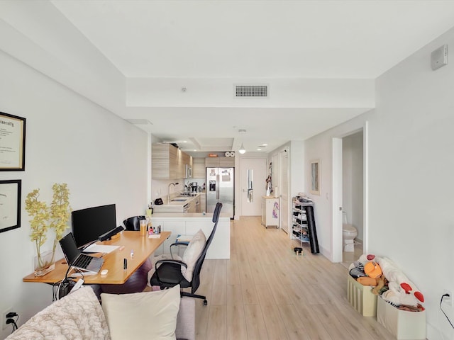 home office featuring light hardwood / wood-style floors and sink