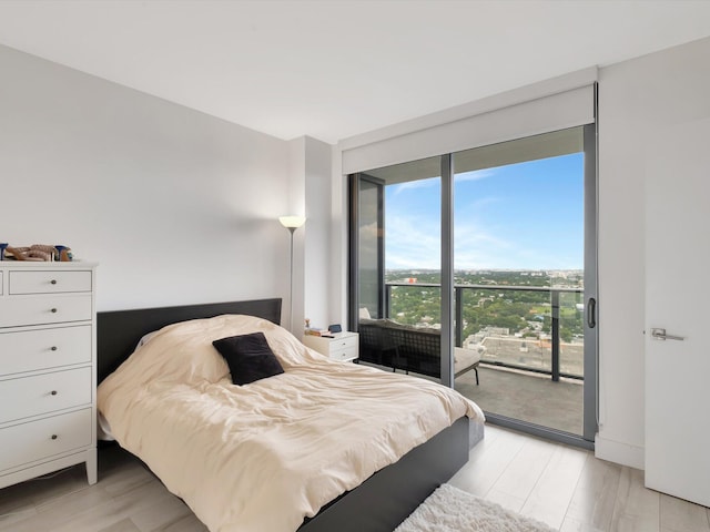 bedroom with light wood-type flooring and access to outside