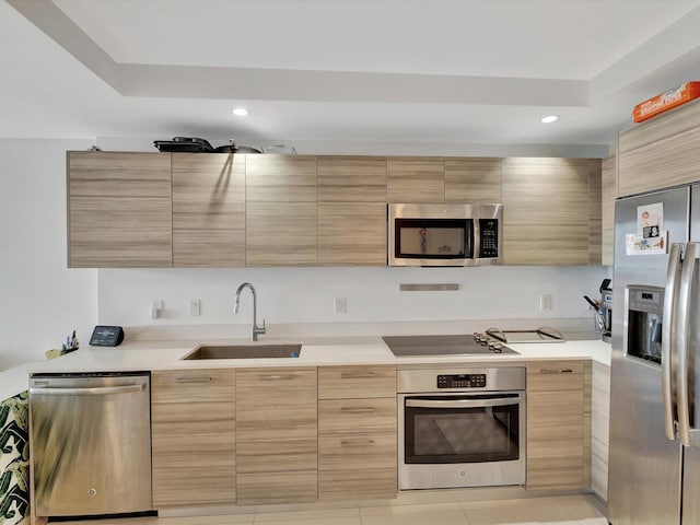 kitchen featuring light brown cabinetry, sink, stainless steel appliances, and light tile patterned floors