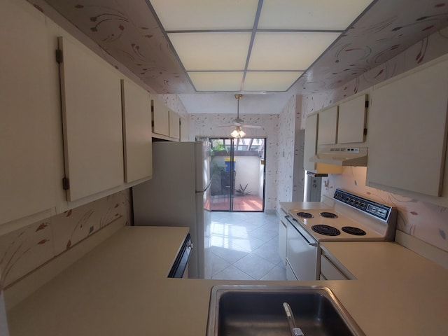 kitchen featuring sink, white cabinetry, hanging light fixtures, and white appliances