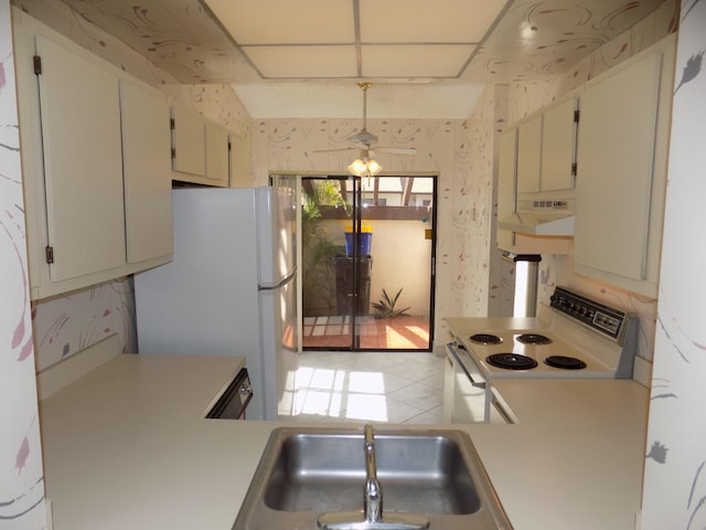 kitchen featuring ceiling fan, sink, hanging light fixtures, and white appliances