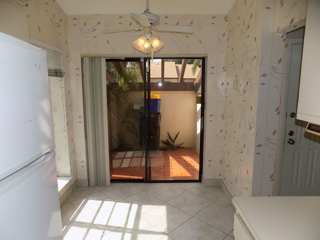 doorway to outside featuring ceiling fan and light tile patterned floors