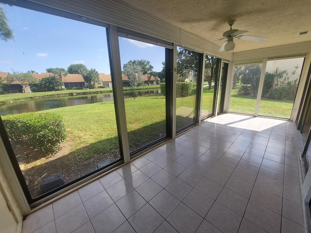 unfurnished sunroom with a water view and ceiling fan