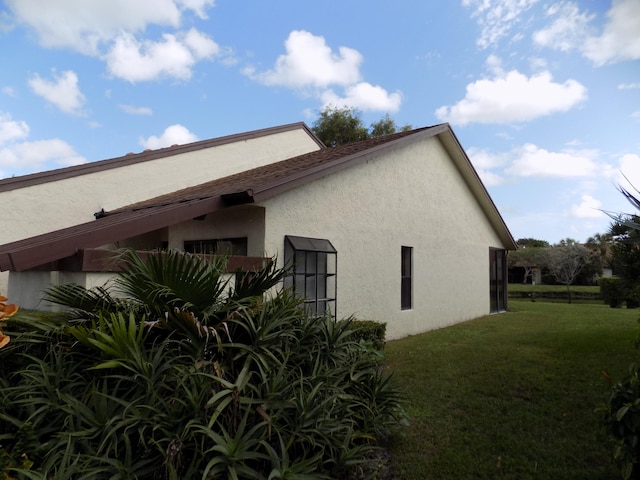 view of side of home with a yard