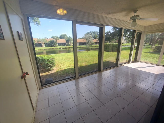 unfurnished sunroom with a water view and ceiling fan