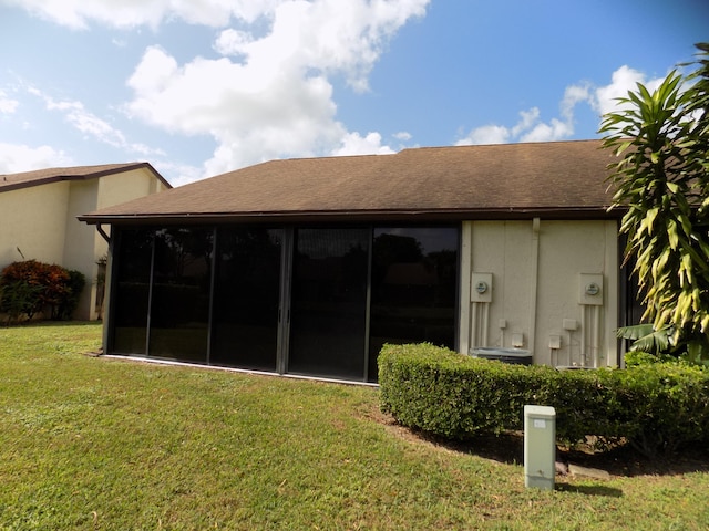 back of property featuring a yard and a sunroom