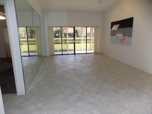 tiled empty room with vaulted ceiling