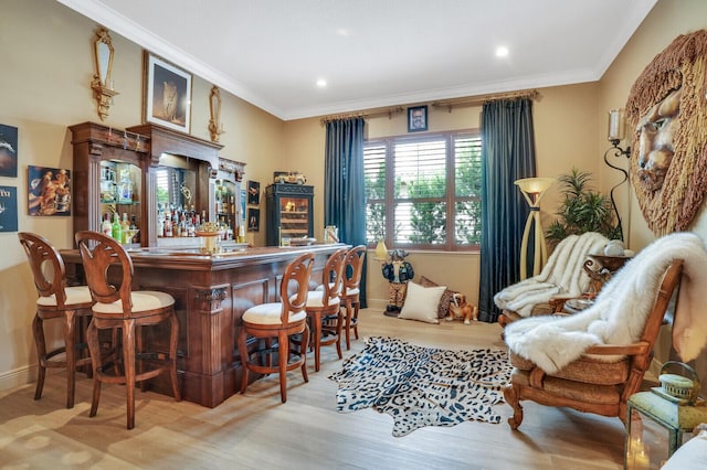 bar with light hardwood / wood-style floors and crown molding