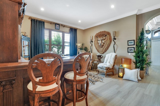 dining room featuring light hardwood / wood-style floors and crown molding