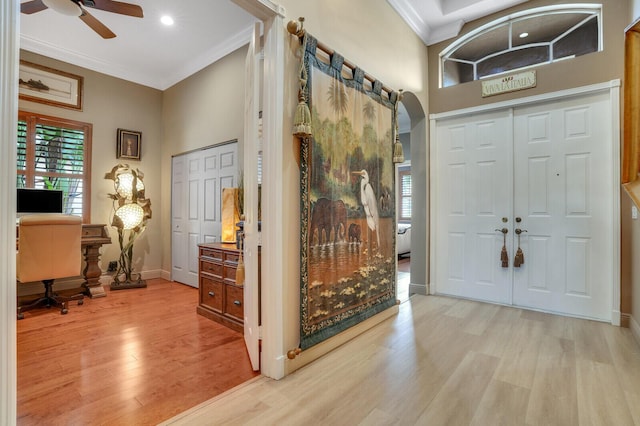 foyer featuring light hardwood / wood-style floors, ceiling fan, and ornamental molding