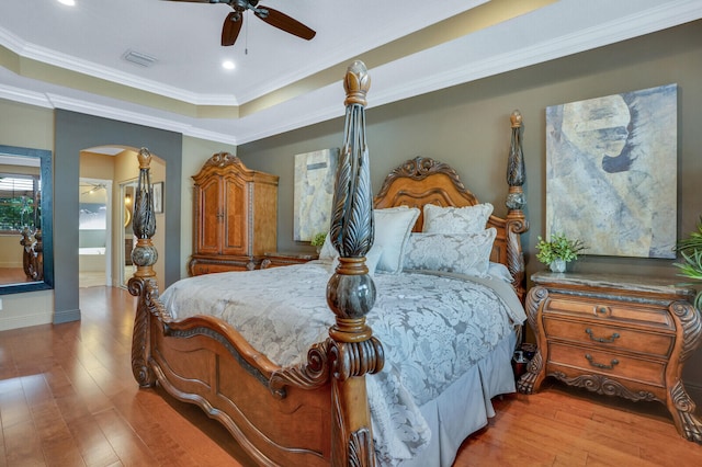 bedroom featuring connected bathroom, ceiling fan, light hardwood / wood-style flooring, and ornamental molding