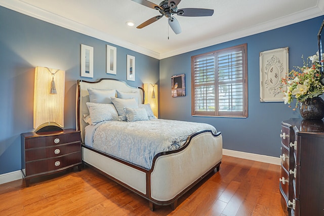 bedroom featuring hardwood / wood-style flooring, ceiling fan, and crown molding