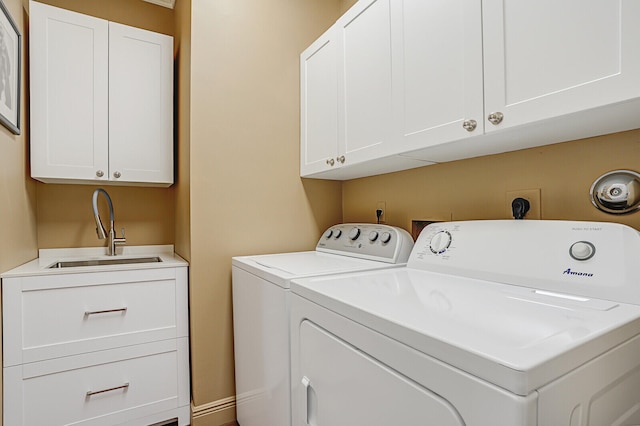 laundry area featuring cabinets, washing machine and dryer, and sink