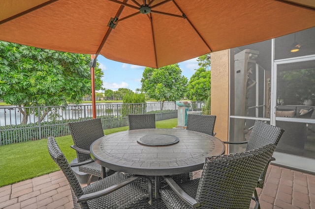 view of patio / terrace with a sunroom and a water view