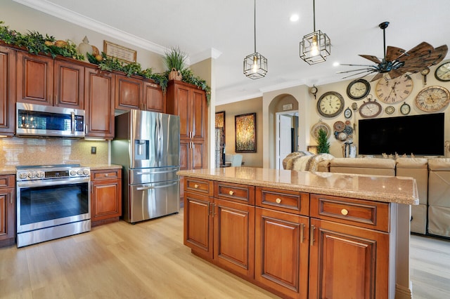 kitchen featuring a center island, crown molding, decorative backsplash, appliances with stainless steel finishes, and decorative light fixtures