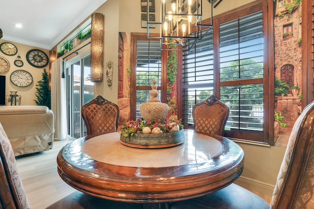 dining space featuring a notable chandelier, wood-type flooring, crown molding, and a wealth of natural light