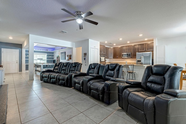 tiled cinema with ceiling fan and a textured ceiling