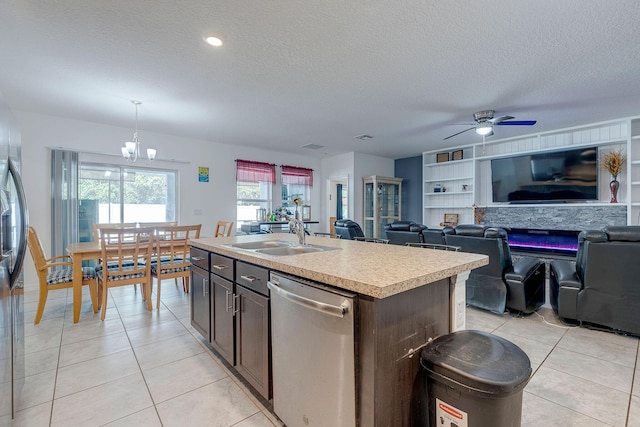 kitchen featuring dark brown cabinetry, sink, decorative light fixtures, an island with sink, and stainless steel appliances