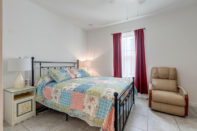 tiled bedroom with ceiling fan and a textured ceiling