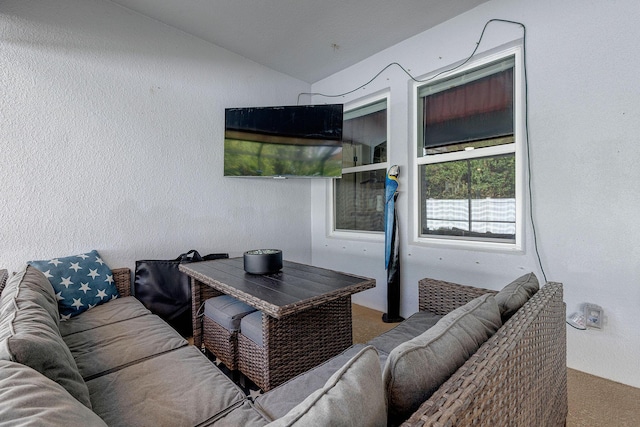 living room featuring lofted ceiling and light carpet