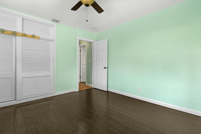 unfurnished bedroom with a closet, ceiling fan, and dark hardwood / wood-style flooring