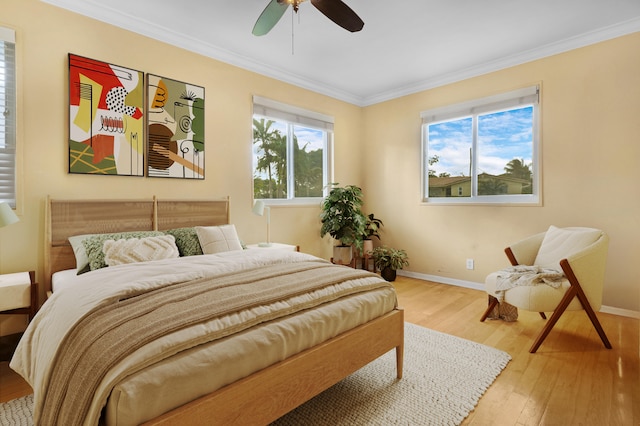 bedroom with multiple windows, ornamental molding, wood-type flooring, and ceiling fan