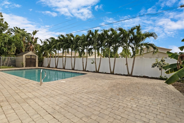 view of pool featuring a shed and a patio area