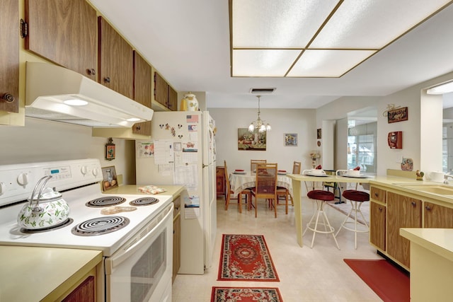 kitchen with a chandelier, sink, decorative light fixtures, and white appliances